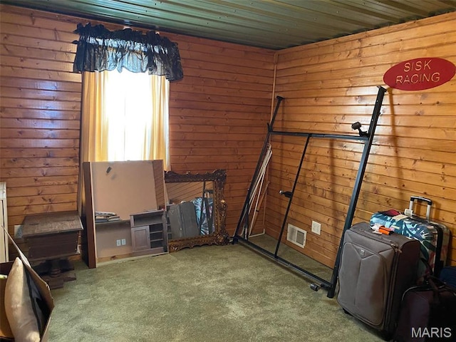 unfurnished bedroom with carpet and wood walls