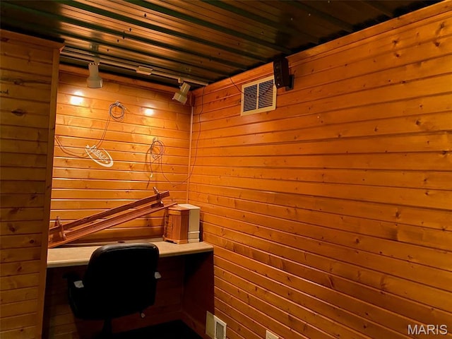 office area with wood walls and built in desk