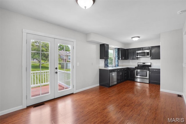 10 Brooker Ct, Saint Peters, MO 63376 - kitchen with appliances with stainless steel finishes, french doors, dark cabinets, light countertops, and decorative backsplash