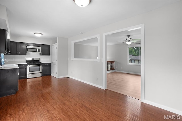 10 Brooker Ct, Saint Peters, MO 63376 - kitchen featuring stainless steel appliances, dark cabinetry, dark wood-style floors, light countertops, and backsplash