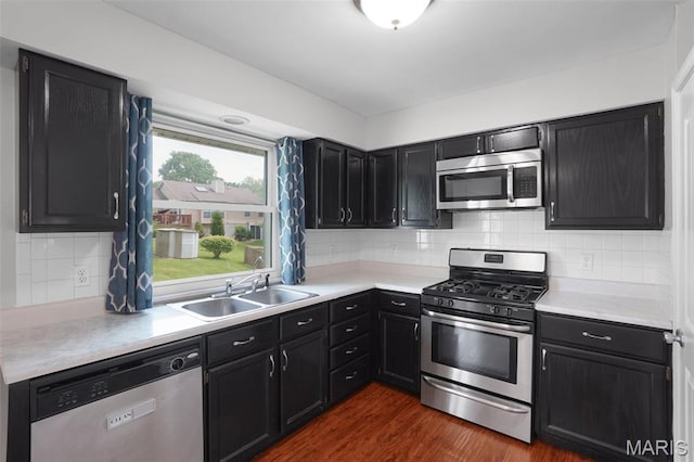 10 Brooker Ct, Saint Peters, MO 63376 - kitchen with appliances with stainless steel finishes, a sink, dark cabinetry, dark wood-style flooring, and light countertops