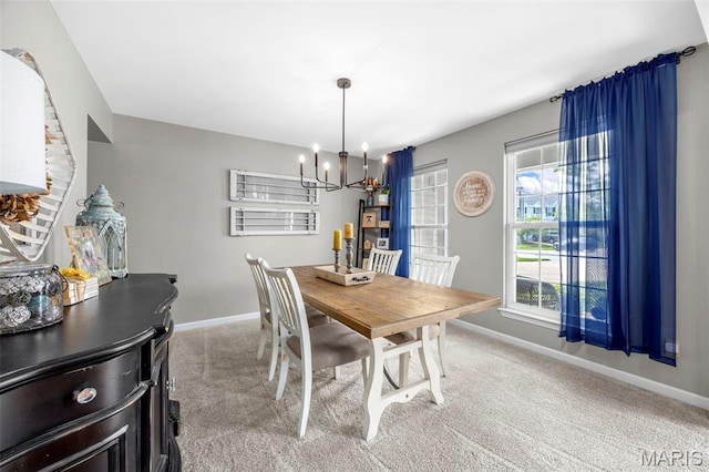dining space featuring a chandelier, baseboards, and carpet flooring