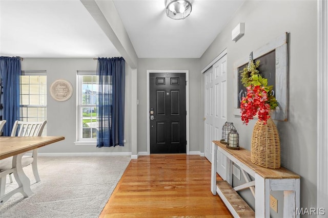 foyer with baseboards and light wood-style flooring