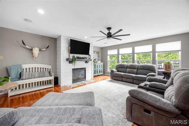 living area with ceiling fan, wood finished floors, recessed lighting, and a fireplace