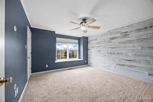 12 Lambeth Ln Unit 11B, Dardenne Prairie, MO 63368 - carpeted empty room featuring a ceiling fan, an accent wall, baseboards, ornamental molding, and wooden walls