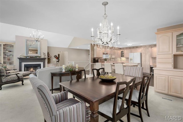 1189 Turnberry Dr, Innsbrook, MO 63390 - dining space featuring a chandelier, light colored carpet, a warm lit fireplace, and recessed lighting