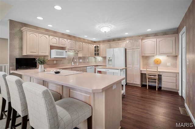 1189 Turnberry Dr, Innsbrook, MO 63390 - kitchen featuring white appliances, a sink, a kitchen breakfast bar, dark wood-style floors, and recessed lighting
