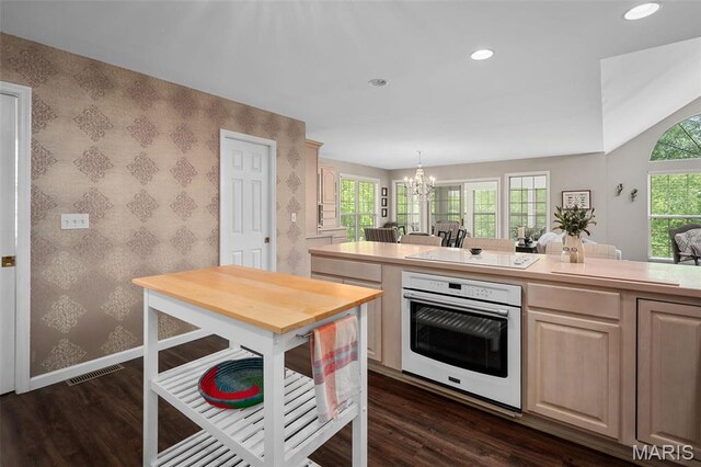 1189 Turnberry Dr, Innsbrook, MO 63390 - kitchen with white appliances, wallpapered walls, baseboards, dark wood-style floors, and a chandelier