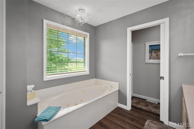 1189 Turnberry Dr, Innsbrook, MO 63390 - full bath with wood finished floors, a whirlpool tub, a chandelier, and baseboards