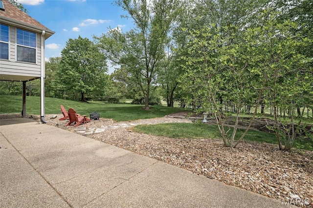 1189 Turnberry Dr, Innsbrook, MO 63390 - view of green lawn with a fire pit, view of scattered trees, and a patio