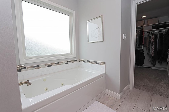 108 Buford Mountain Rd, Farmington, MO 63640 - bathroom with a whirlpool tub, a spacious closet, and baseboards