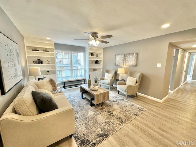 living room featuring light wood-type flooring, baseboards, ceiling fan, built in features, and recessed lighting