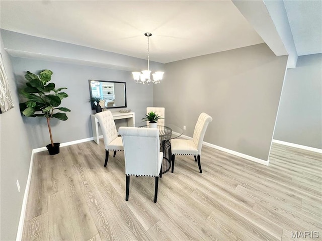 dining room with light wood-style floors, baseboards, and a chandelier