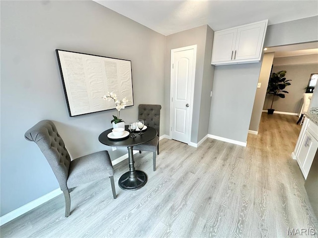 dining room featuring light wood-type flooring and baseboards