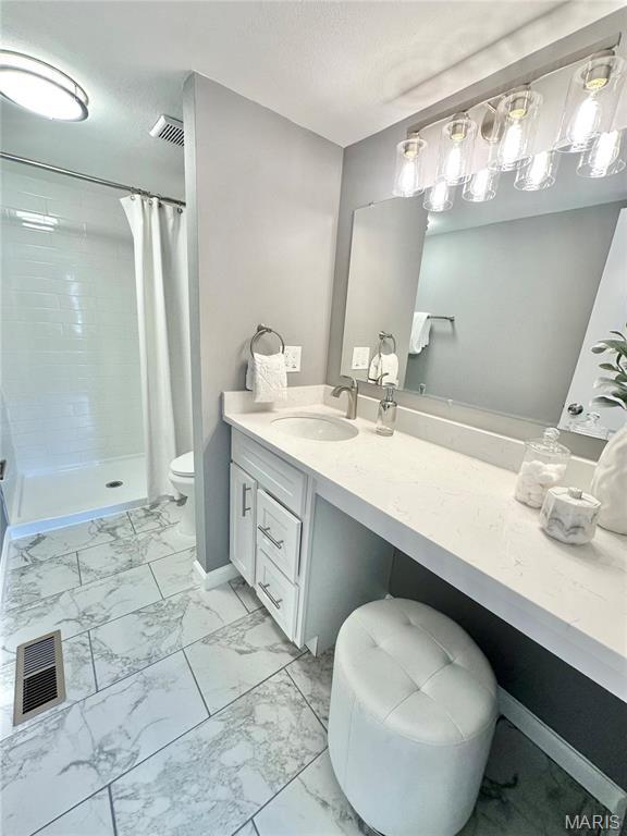 full bathroom with marble look tiles, a shower stall, and vanity
