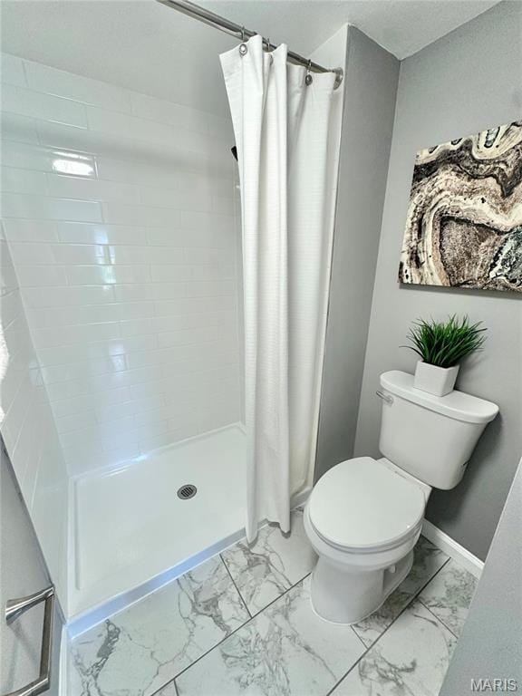 bathroom with marble look tile flooring, toilet, a stall shower, and baseboards