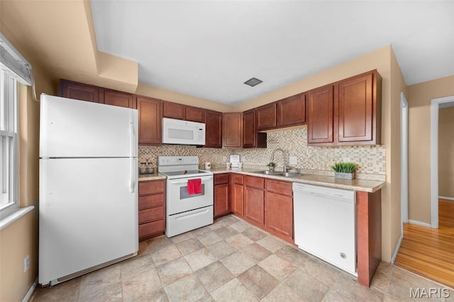 kitchen with white appliances, a sink, light countertops, and tasteful backsplash