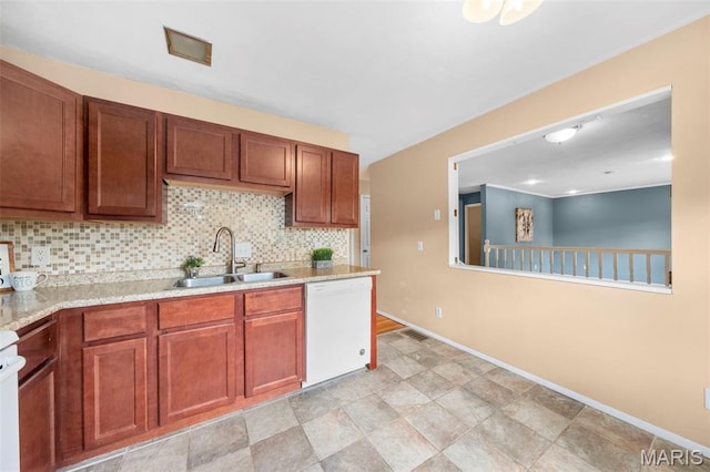 kitchen featuring dishwasher, a sink, decorative backsplash, and baseboards