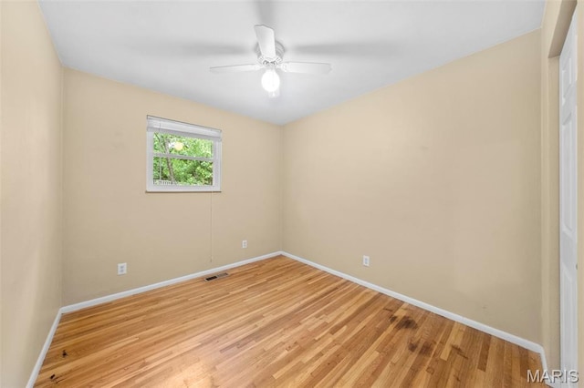 empty room featuring baseboards, light wood finished floors, and ceiling fan
