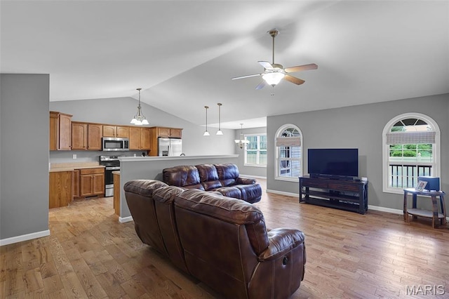 living area featuring lofted ceiling, light wood finished floors, ceiling fan, and baseboards