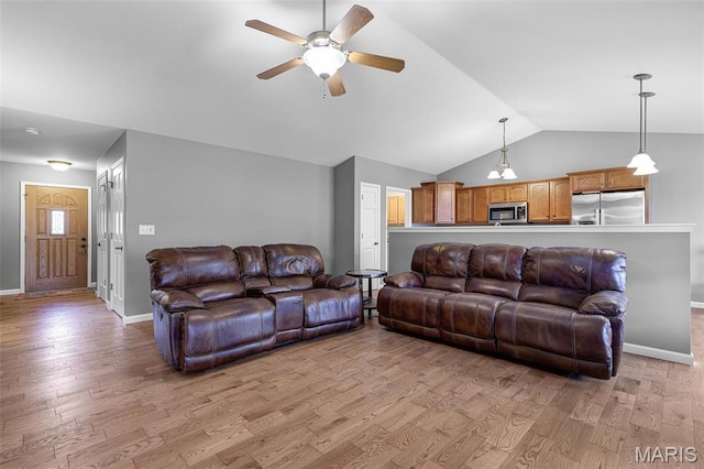 living room with vaulted ceiling, ceiling fan, light wood-style flooring, and baseboards