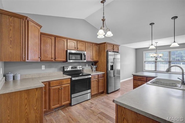 kitchen with stainless steel appliances, a chandelier, vaulted ceiling, brown cabinets, and light wood-style flooring
