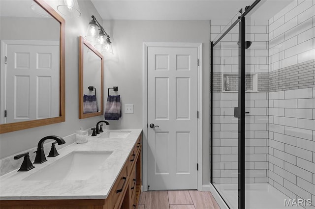 bathroom featuring a shower stall and double vanity