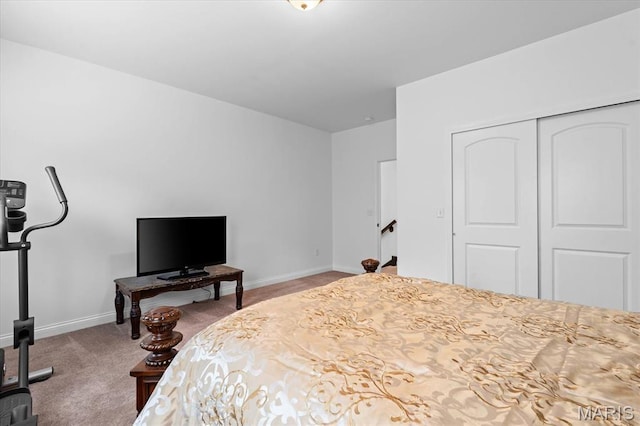 carpeted bedroom featuring baseboards and a closet