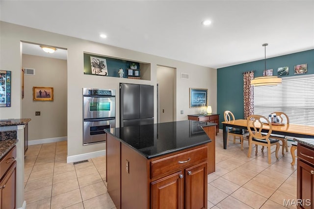 kitchen with refrigerator, double oven, light tile patterned floors, pendant lighting, and brown cabinetry