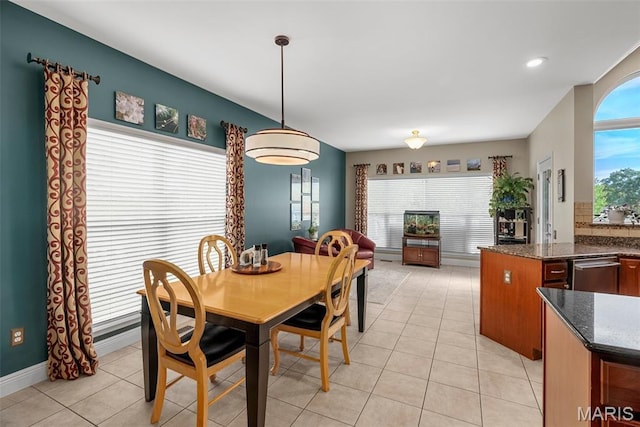 dining space featuring light tile patterned floors and baseboards