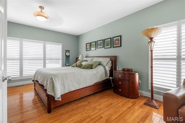 bedroom featuring light wood-style floors and baseboards
