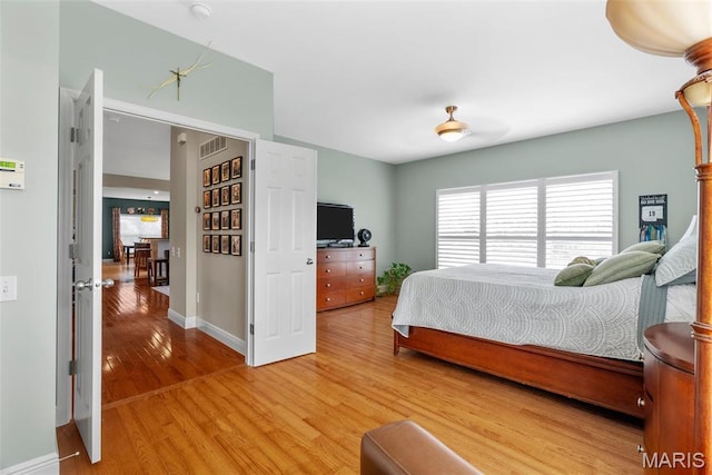 bedroom with light wood-type flooring and baseboards