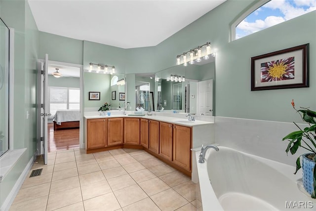 ensuite bathroom featuring tile patterned floors, a garden tub, and double vanity