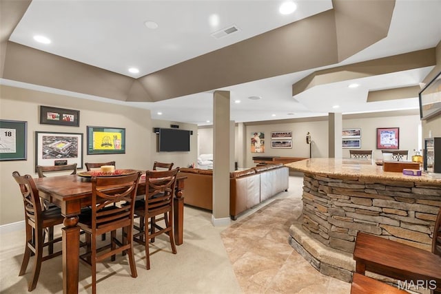 dining space featuring wet bar, recessed lighting, baseboards, and light colored carpet