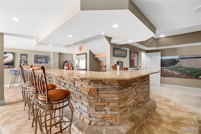 indoor wet bar featuring stainless steel fridge, recessed lighting, and baseboards