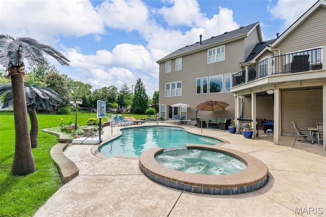 view of pool with a patio area, a pool with connected hot tub, and a lawn