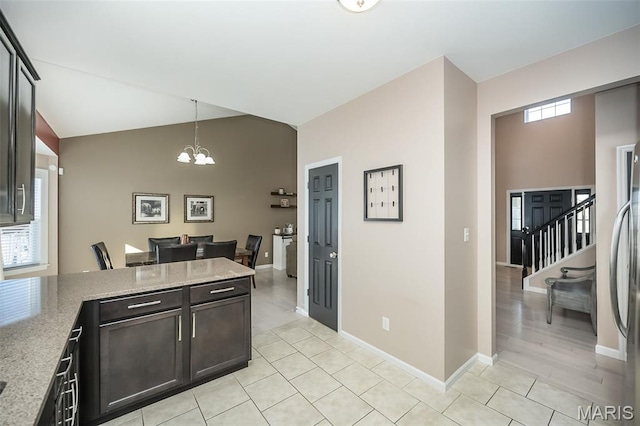 1119 Maywood Dr, Eureka, MO 63025 - kitchen featuring a chandelier, vaulted ceiling, light tile patterned flooring, a peninsula, and pendant lighting