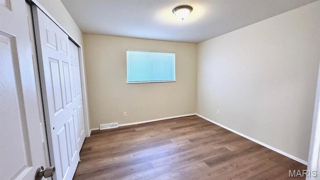 4028 Esseldale Dr, Saint Ann, MO 63074 - unfurnished bedroom featuring wood finished floors, baseboards, and a closet