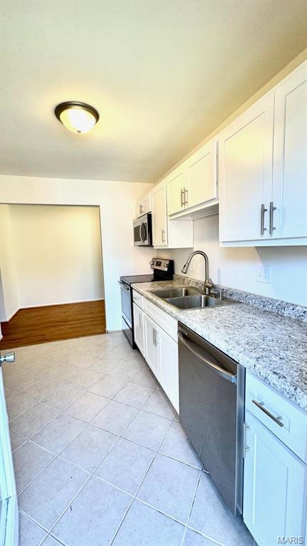 4028 Esseldale Dr, Saint Ann, MO 63074 - kitchen featuring stainless steel appliances, a sink, white cabinets, and light tile patterned floors