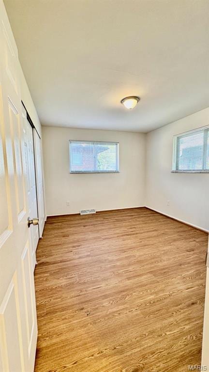 4028 Esseldale Dr, Saint Ann, MO 63074 - unfurnished bedroom with multiple windows, wood finished floors, and a closet