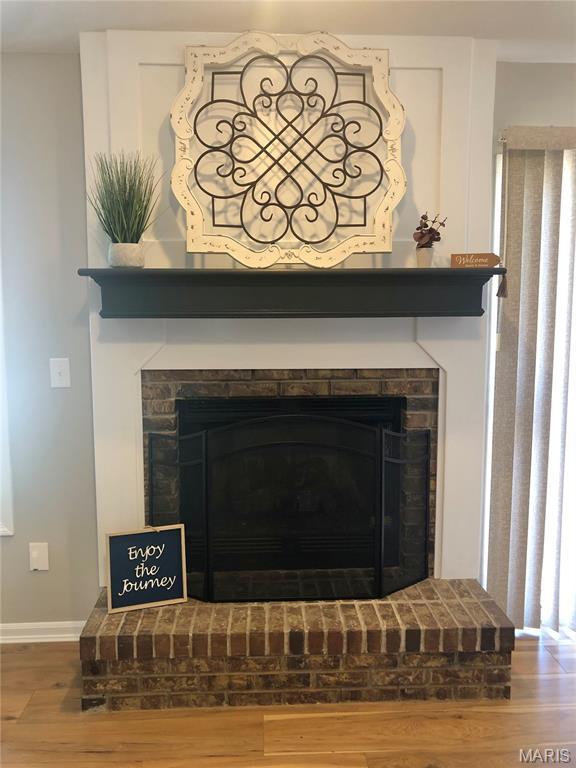 1215 Brookstone Ln, Lake St Louis, MO 63367 - detailed view of wood finished floors, a fireplace, and baseboards