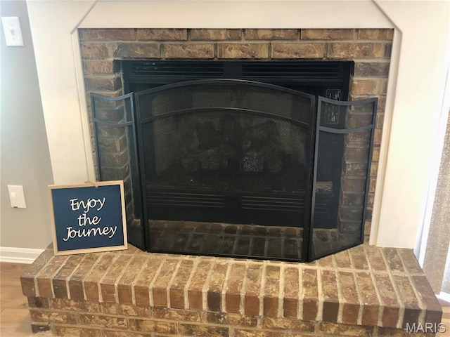 1215 Brookstone Ln, Lake St Louis, MO 63367 - detailed view of a fireplace with raised hearth, wood finished floors, and baseboards