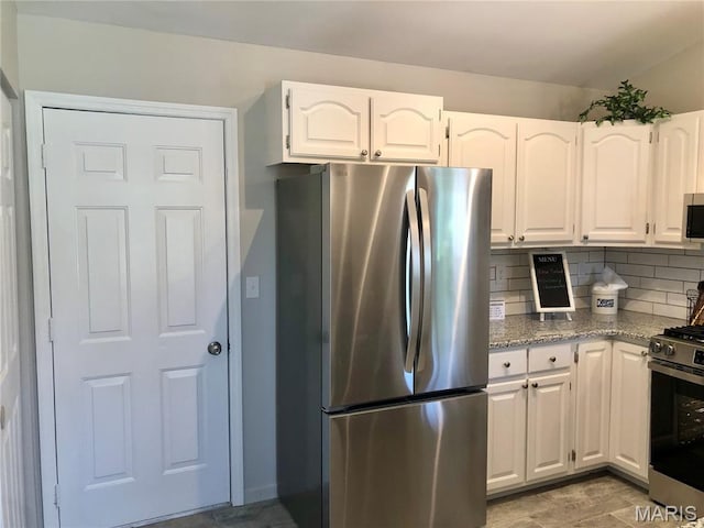 1215 Brookstone Ln, Lake St Louis, MO 63367 - kitchen with stainless steel appliances, white cabinetry, decorative backsplash, and light stone countertops