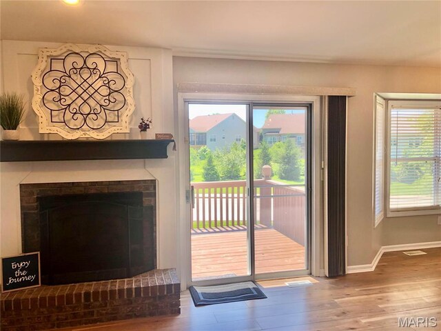 1215 Brookstone Ln, Lake St Louis, MO 63367 - doorway featuring wood finished floors, baseboards, and a brick fireplace