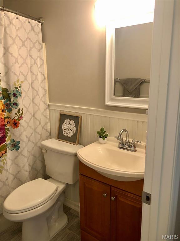 1215 Brookstone Ln, Lake St Louis, MO 63367 - bathroom featuring wainscoting, toilet, vanity, and a shower with shower curtain