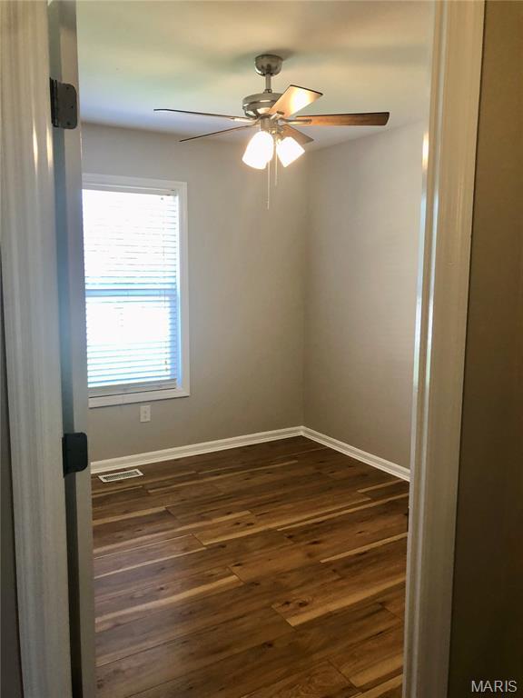 1215 Brookstone Ln, Lake St Louis, MO 63367 - unfurnished room with dark wood-type flooring, baseboards, and ceiling fan