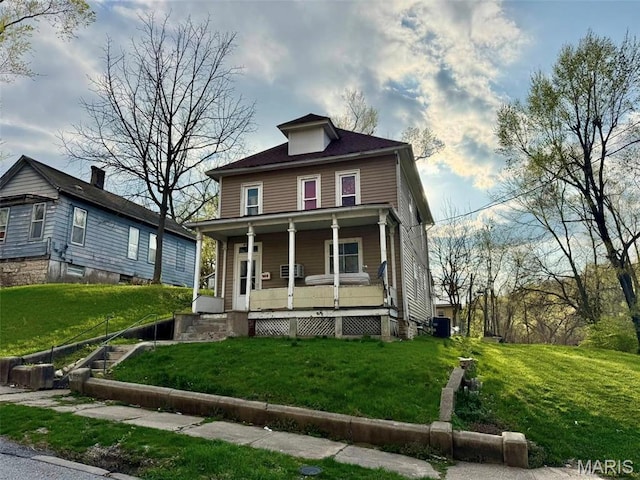 traditional style home with covered porch, a front lawn, and cooling unit