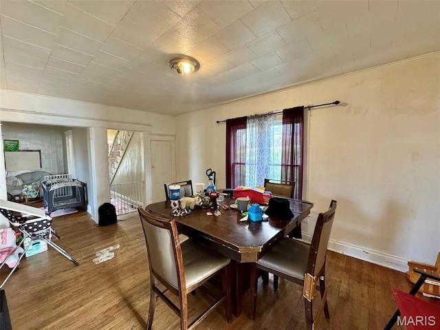 dining room with wood finished floors, stairs, and baseboards