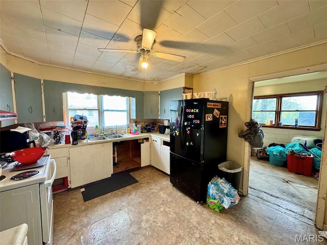kitchen with freestanding refrigerator, white range with electric cooktop, a sink, light countertops, and a ceiling fan