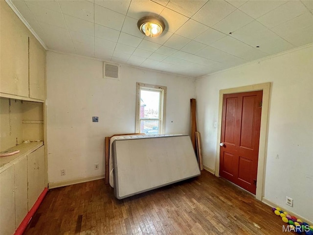 spare room with wood-type flooring, crown molding, and baseboards